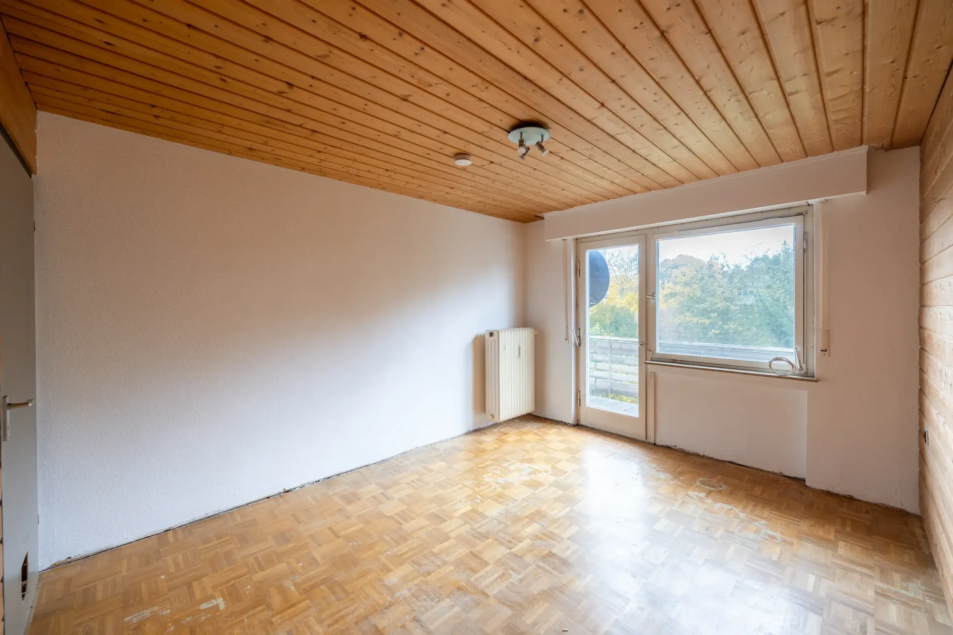 Helles Zimmer mit Zugang auf den Balkon und Blick ins Grüne