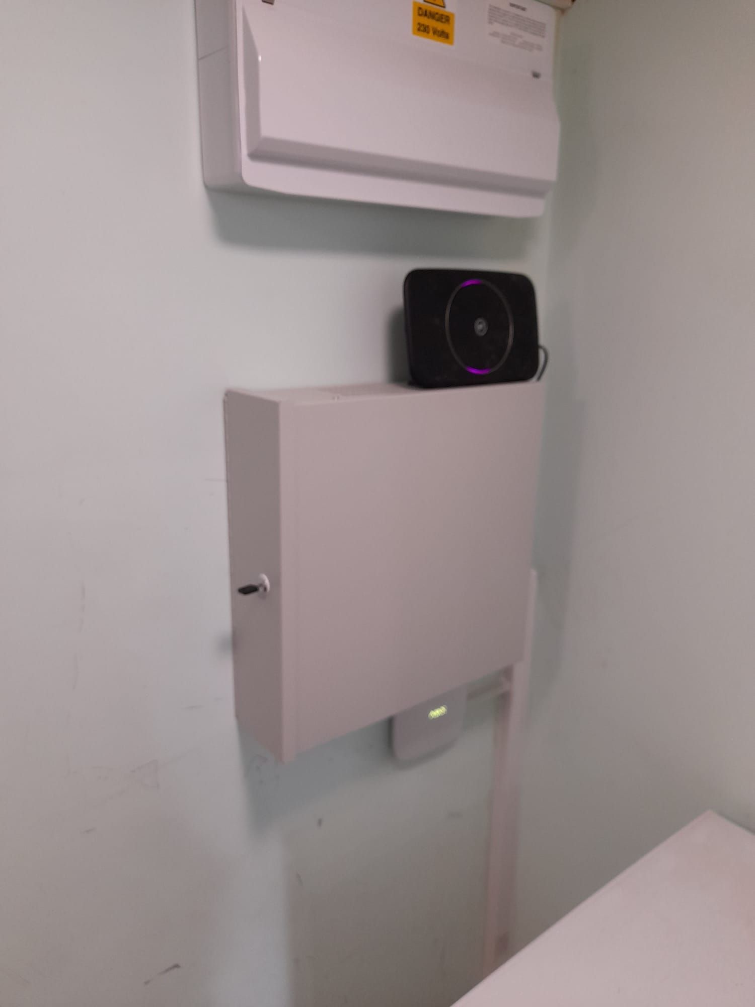 Mounted electrical box with a Wi-Fi router and a network device installed on a wall.