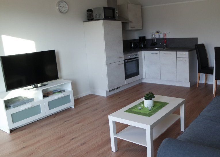 Wohnzimmer mit gemütlichem 3er Sofa, Esstisch und moderner Küche mit kompletter Ausstattung