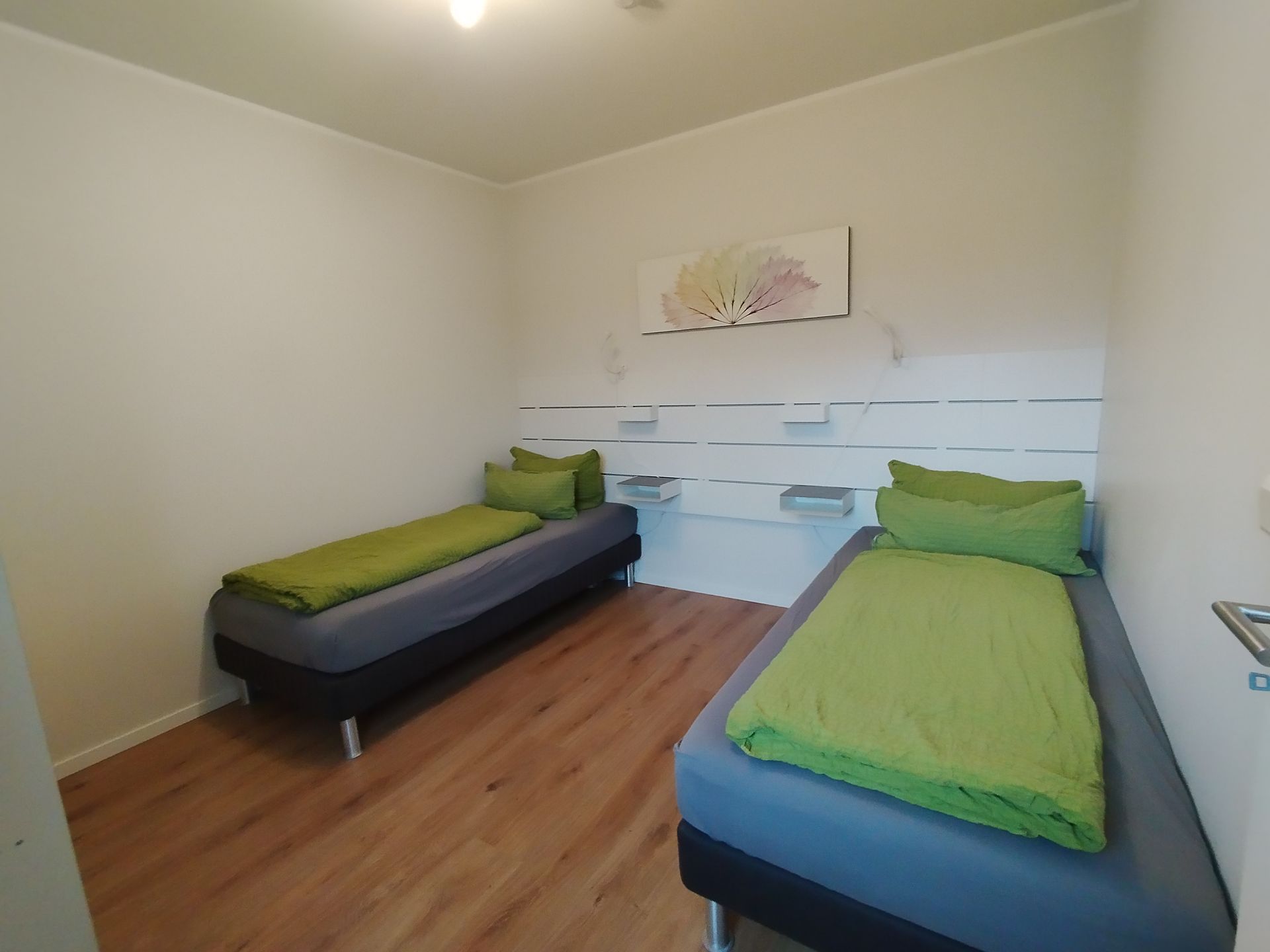 Schlafzimmer mit zwei bequemen Boxspringbetten und Kleiderschrank