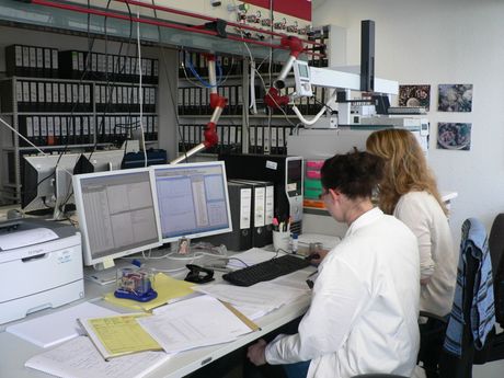 Photo of two female chemists in front of computer screens checking data.