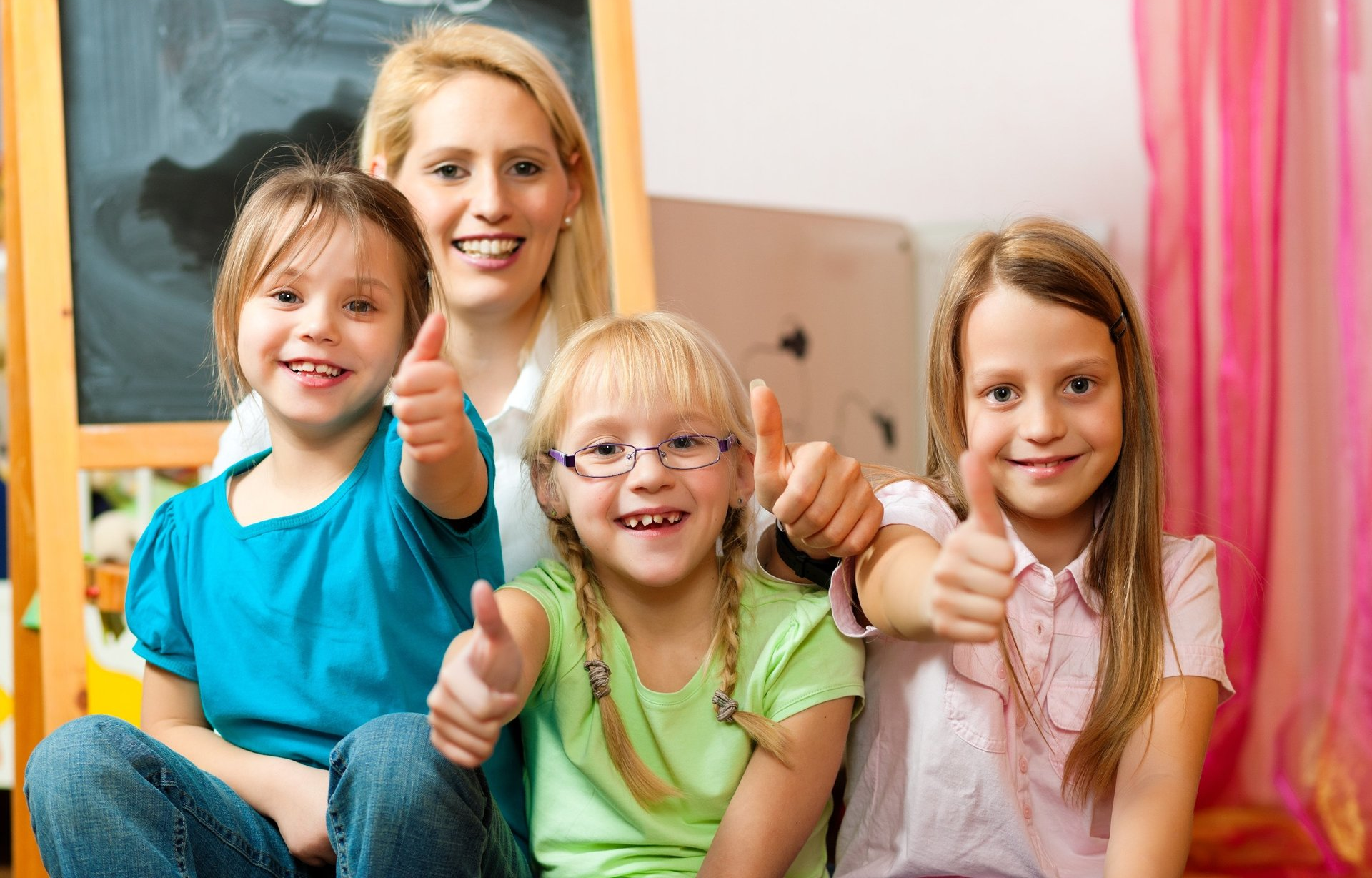 Una maestra e tre bambine a scuola