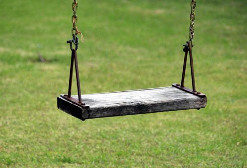 Partnerschaftliches Anliegen. Link zu Terminbuchung leere Schaukel vor grüner Wiese