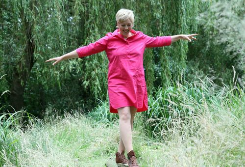 Meine besondere berufliche Qualifikation. Susanne Feußahrens, Ärztliche Praxis für Hypnosetherapie in Diepholz breitet die Arme aus, im Hintergrund sieht man ein Kornfeld. Genießerisch, frei.