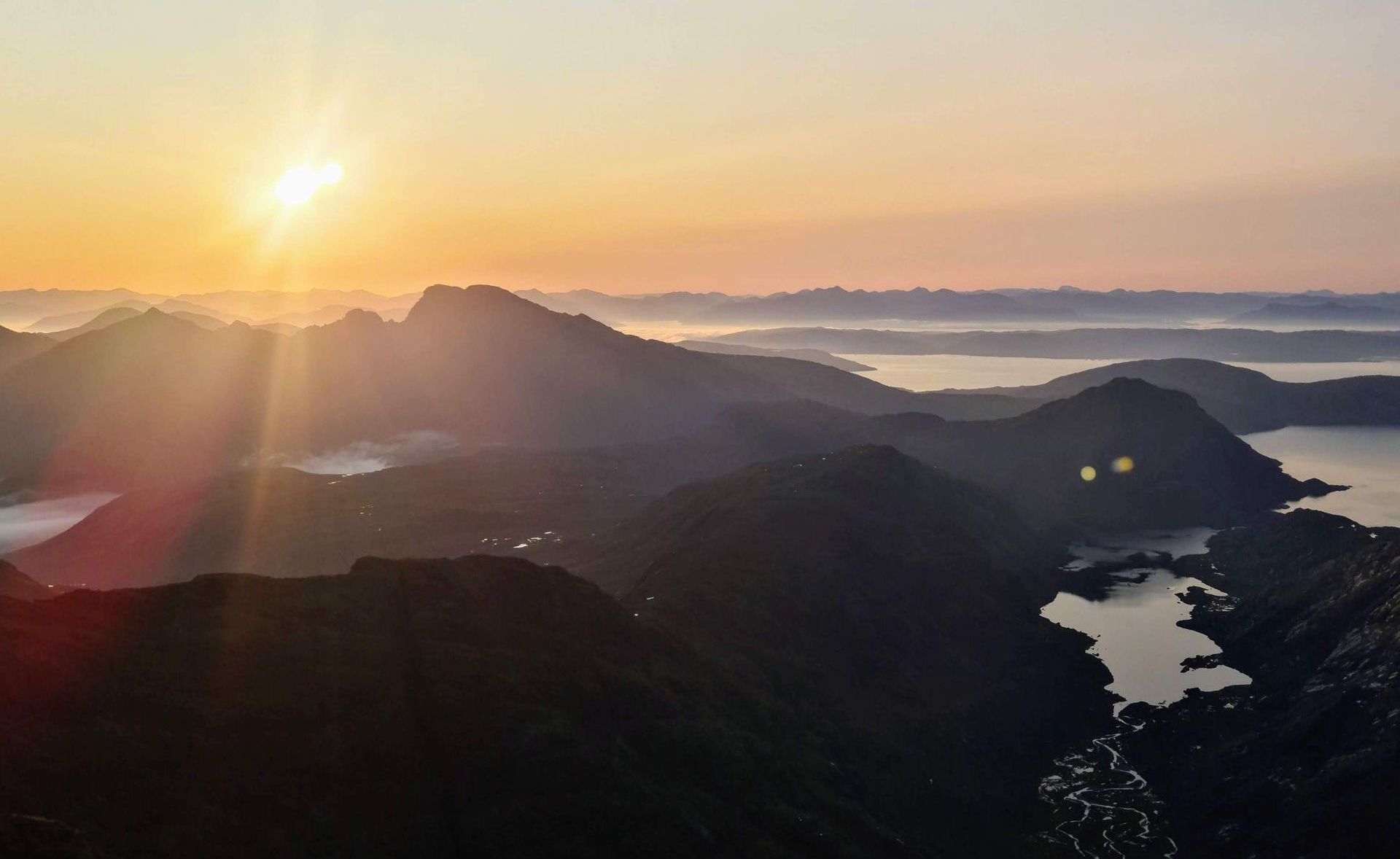 Sunrise on a Skye Cuillin ridge traverse. Looking east across to Bla Bheinn and beyond to the mainland