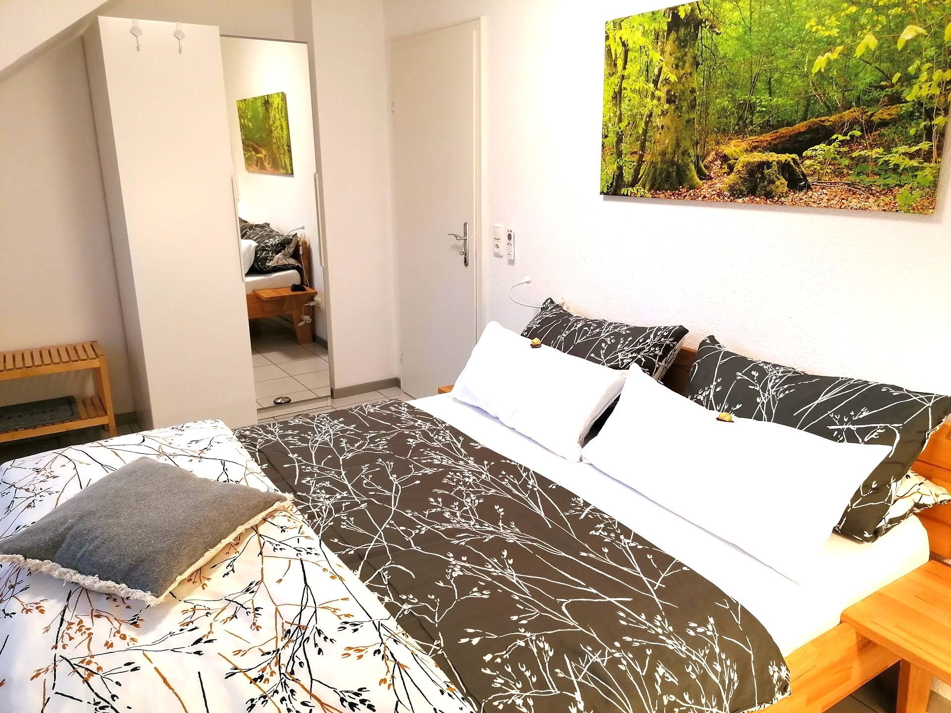Fewo Grete, Trier: Schlafzimmer mit 160 cm Doppelbett.  Ferienwohnung Grete in Trier: Schlafzimmer mit 160 cm Doppelbett. Matratze am Kopfende neigungsverstellbar. Matratzen mit harter und weicher Seite. Kleiderschrank mit genügend Stauraum -  ausreichend Kleiderbügel vorhanden. Regal mit diversen Büchern. Dimmbare Deckenleuchte. Ausblick in den Garten.