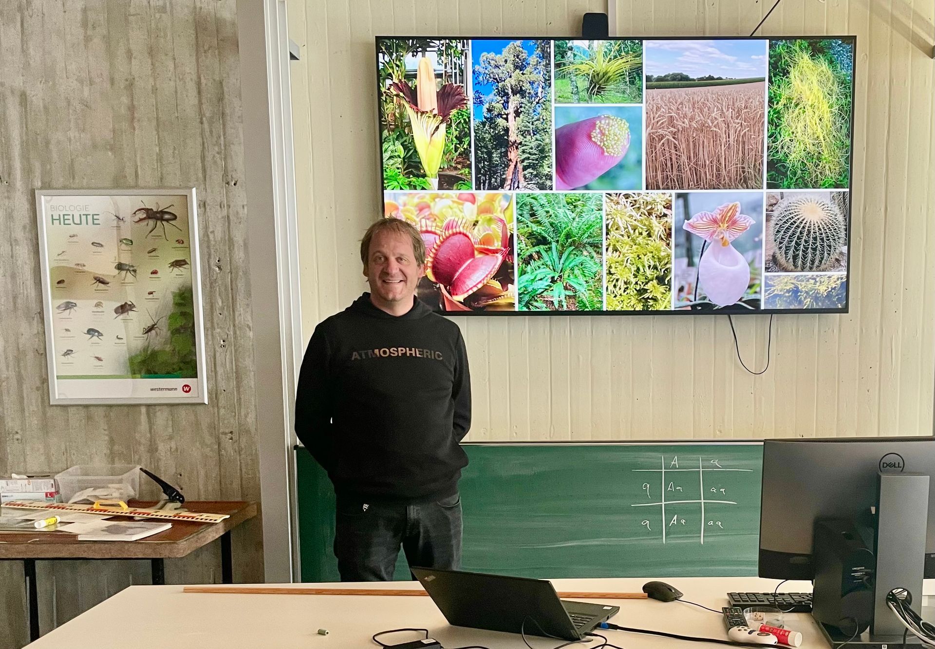 Herr Poppinga vor dem Whiteboard mit biologischen Darstellungen