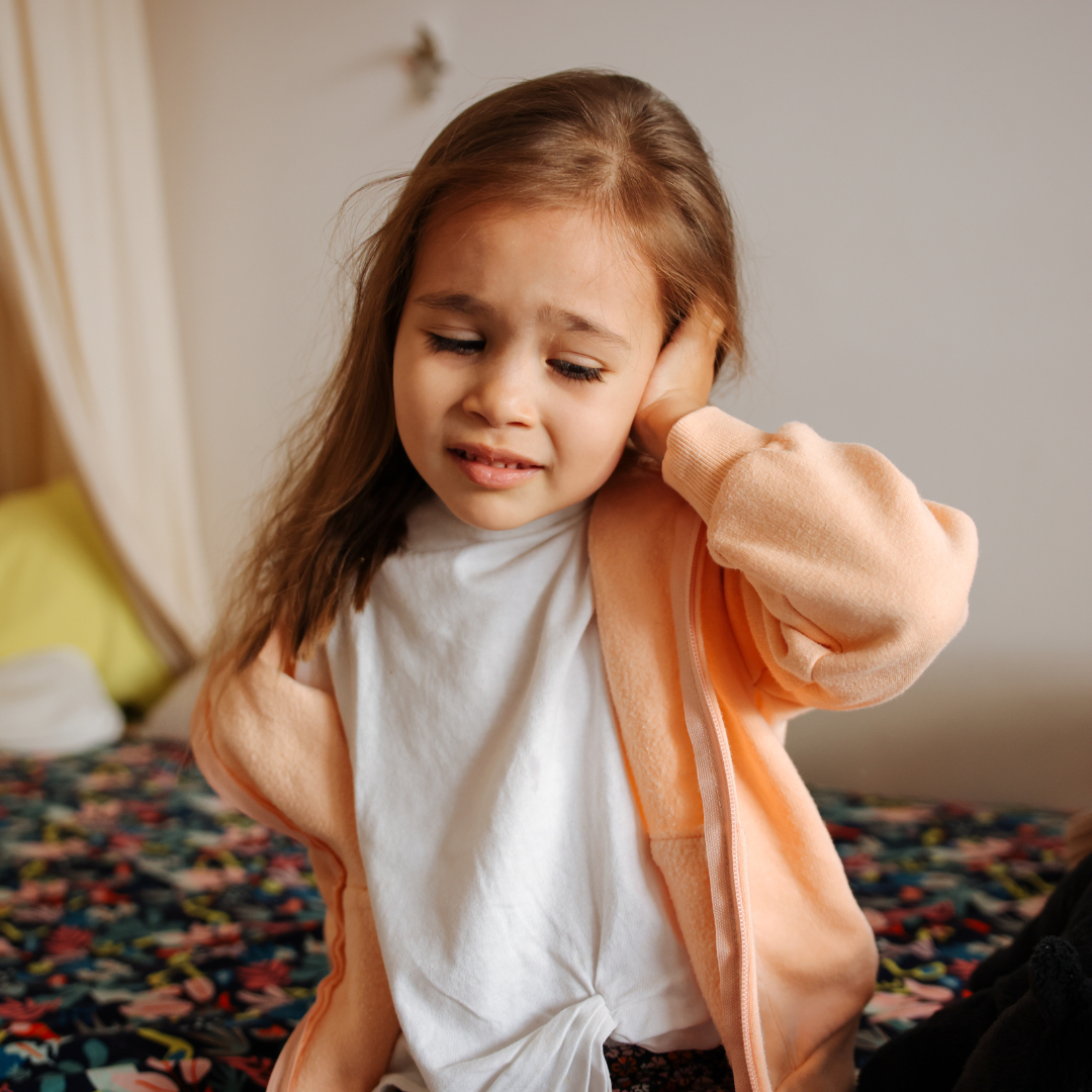 girl holding ear in pain