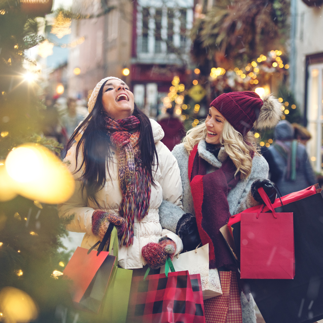 two women christmas shopping and laughing