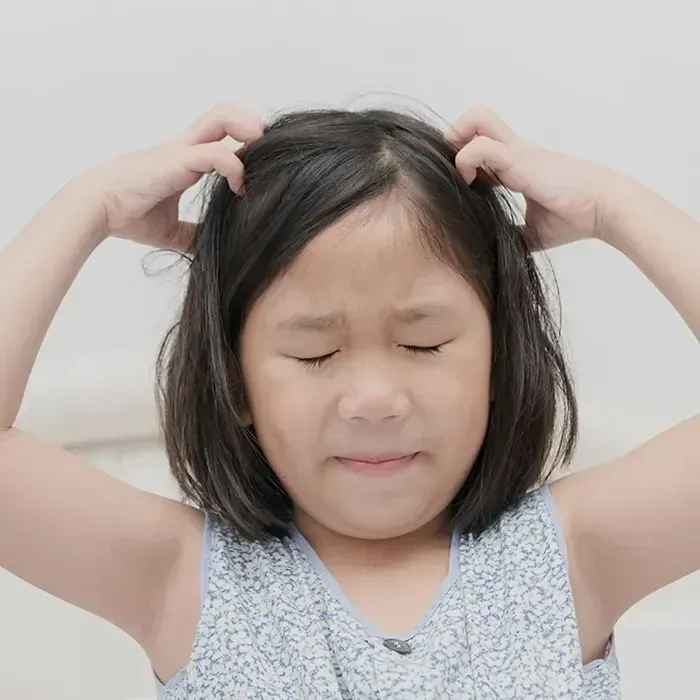 girl scratching head