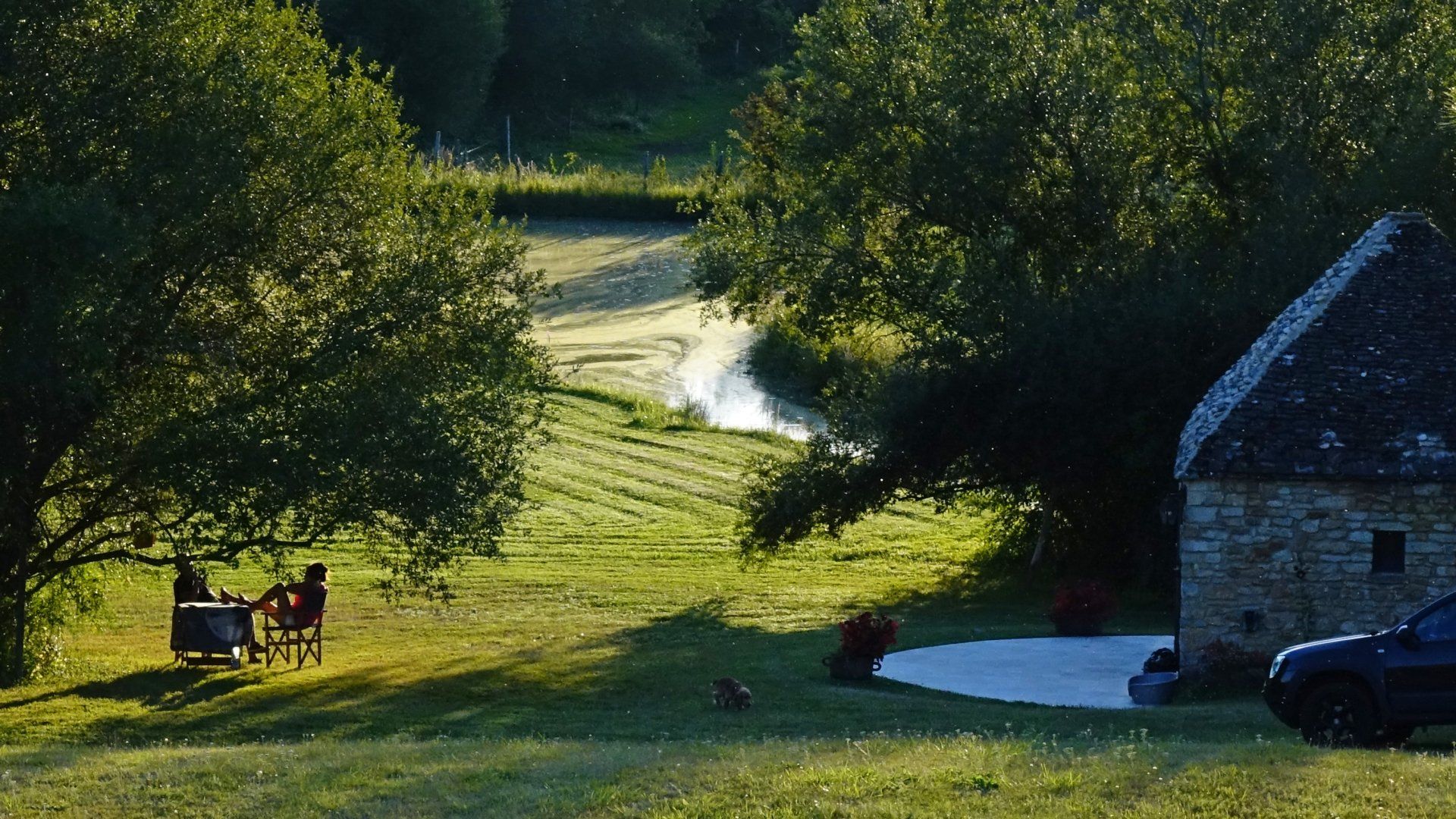 Vue du parc et à l'arrière plan de l'étang. Lumière chaude du coucher de soleil sur le salon de jardin