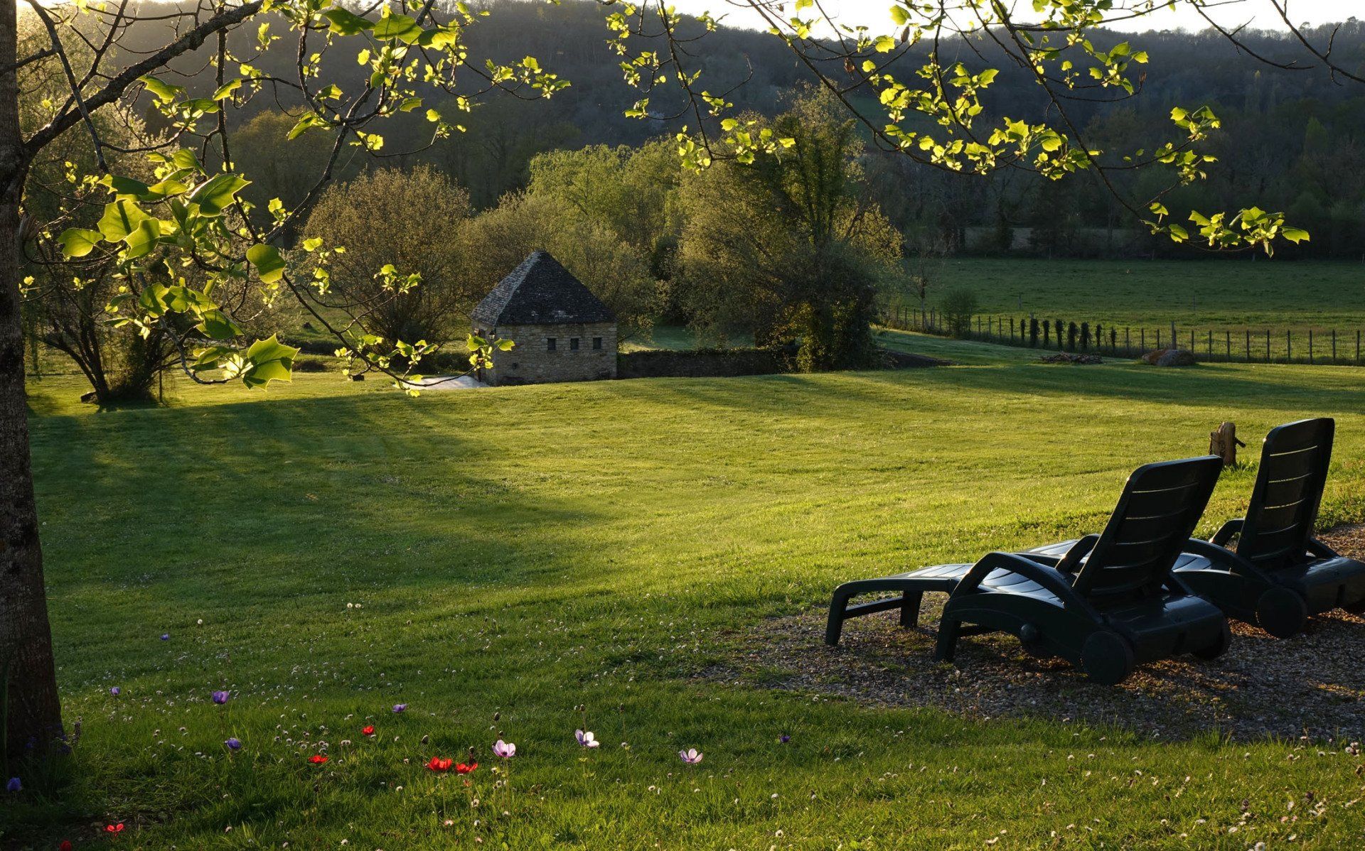 Vue du pré et de la maison en pierre