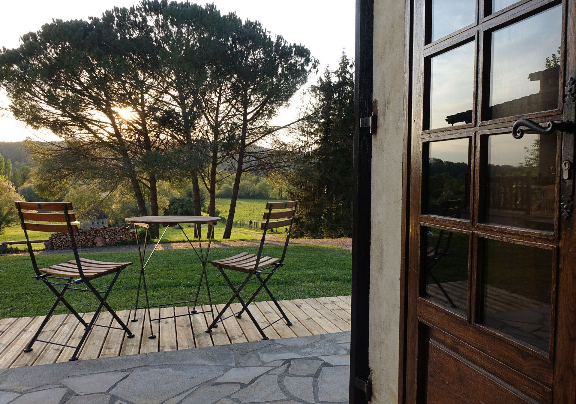 Chambre d'hôtes Sérénité vue sur la terrasse, petite table en bois et ses deux chaises..
