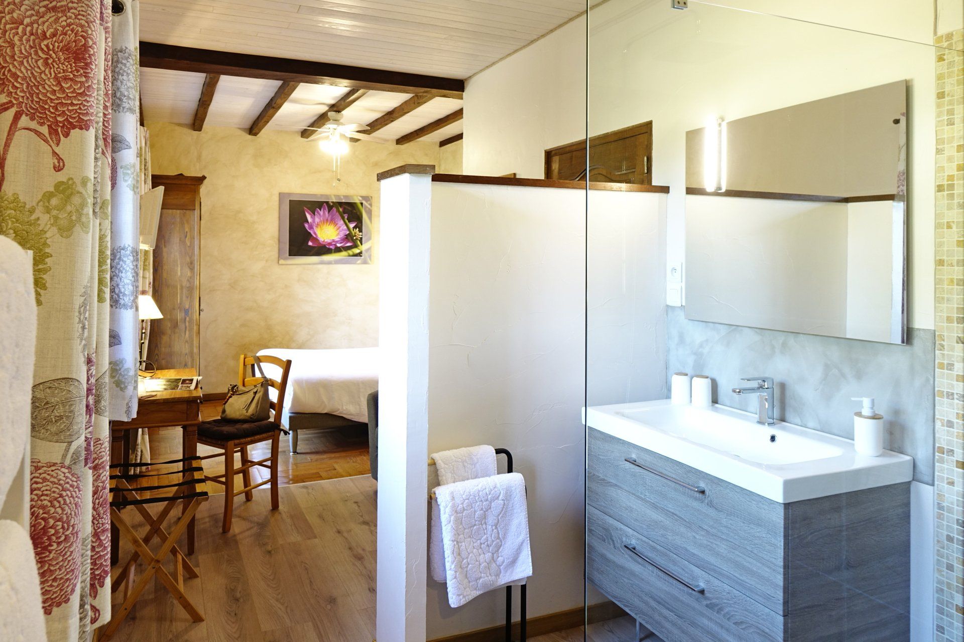 Vue intérieure chambre Sérénité, salle de bain avec lavabo blanc, miroir et porte serviettes