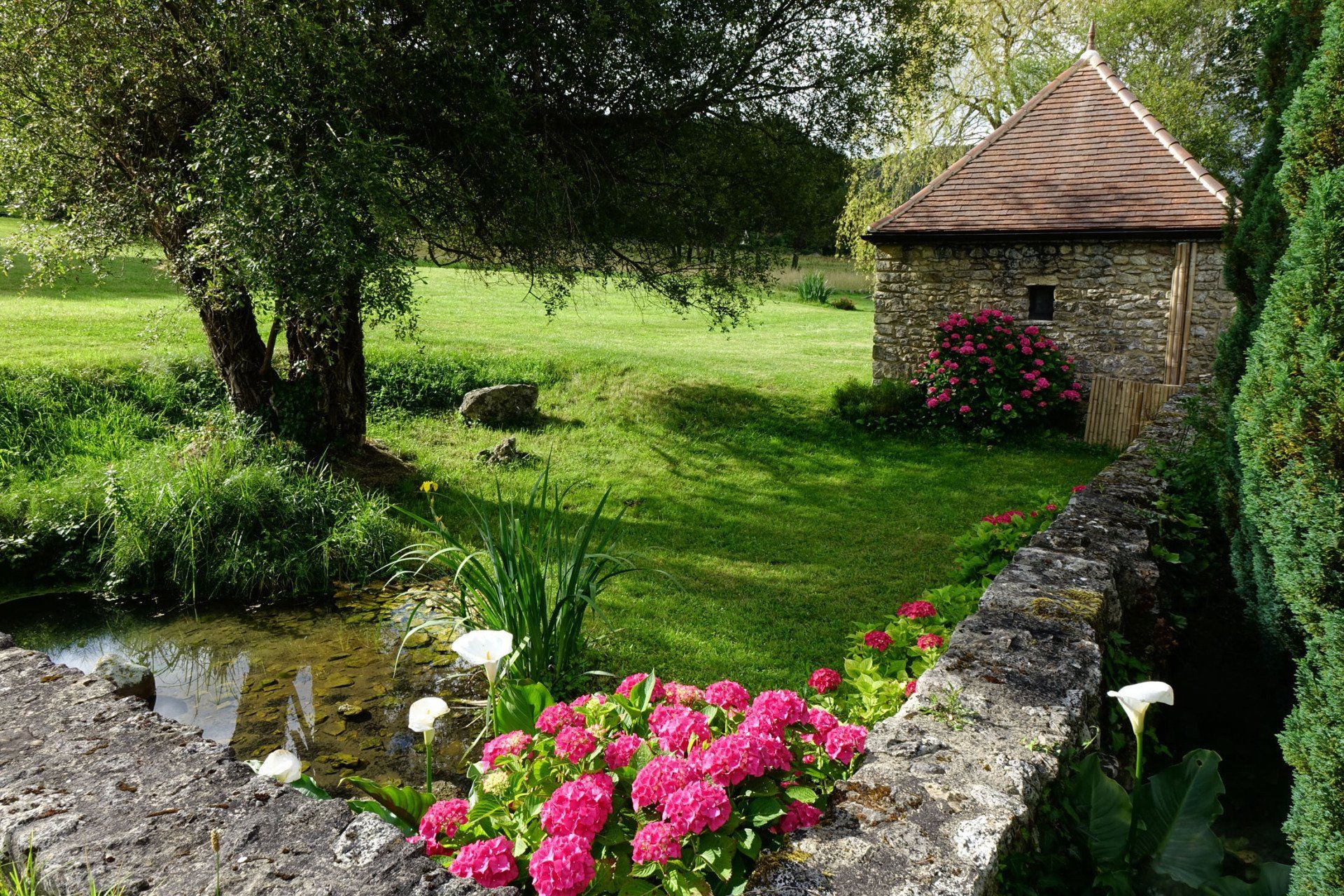 Vue de la source et l'arrière de la chambre La Borie, petite maison en Pierres