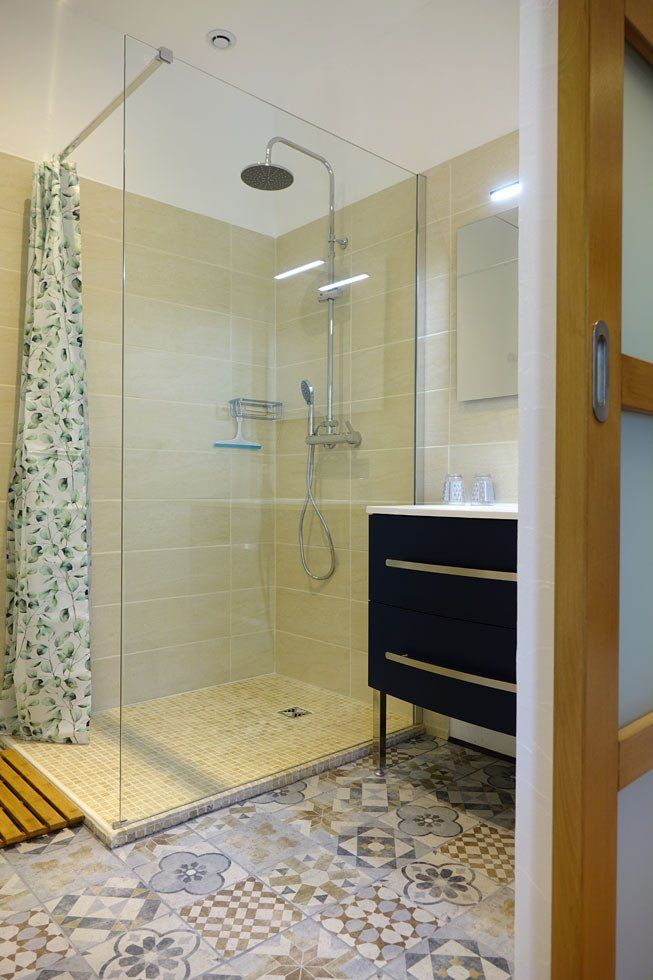 Salle de bain avec douche à l'italienne, lavabo et miroir