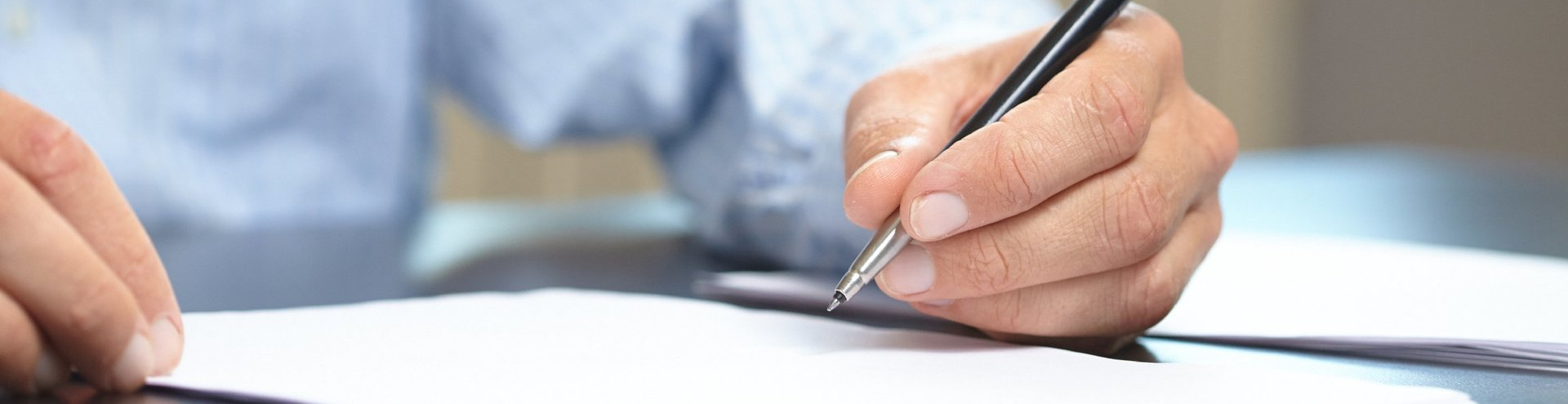 Beratung und Hilfe bei Erstellung von Vorsorgevollmacht, Betreuungsverfügung und Patientenverfügung Foto Ausschnitt jemand schreibt etwas mit einem Kugelschreiber auf ein noch leeres Blatt Papier