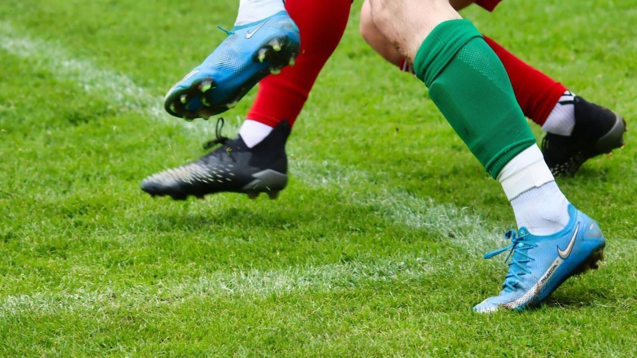 Players tackling with properly fitted shin guards secured under socks