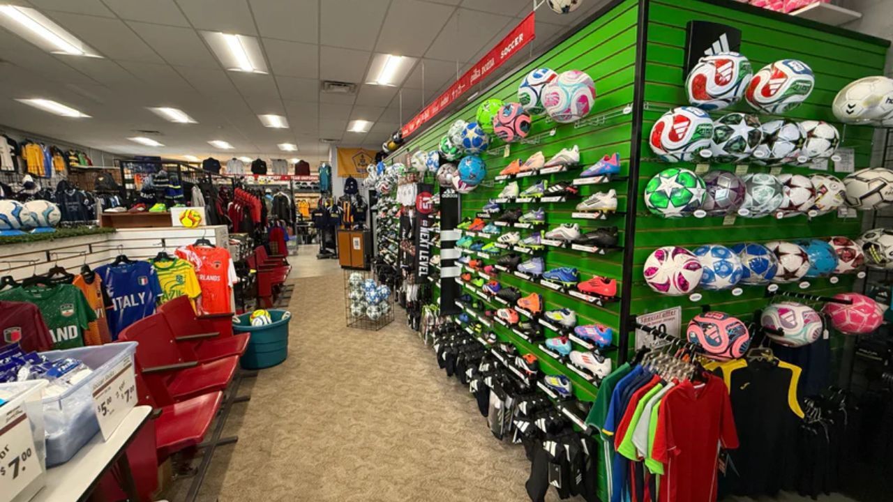 Soccer gear section at DMK Sports with cleats, balls, and jerseys displayed on store shelves
