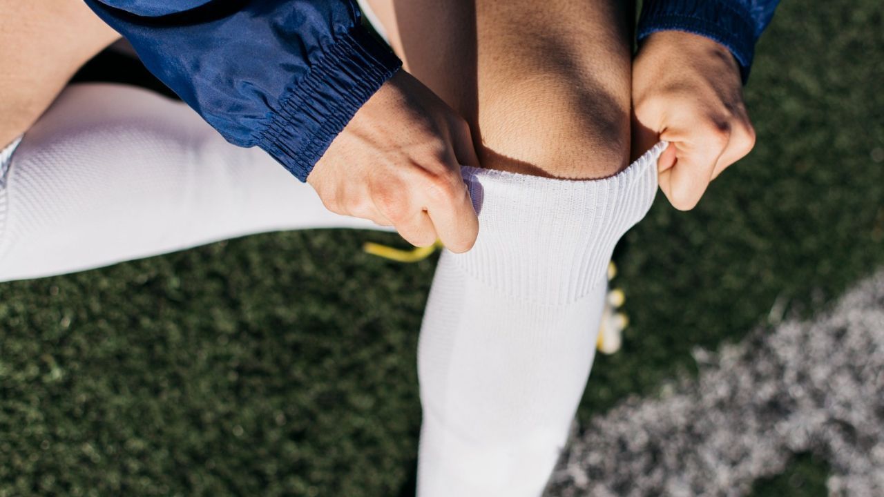 Player adjusting socks and shin guards