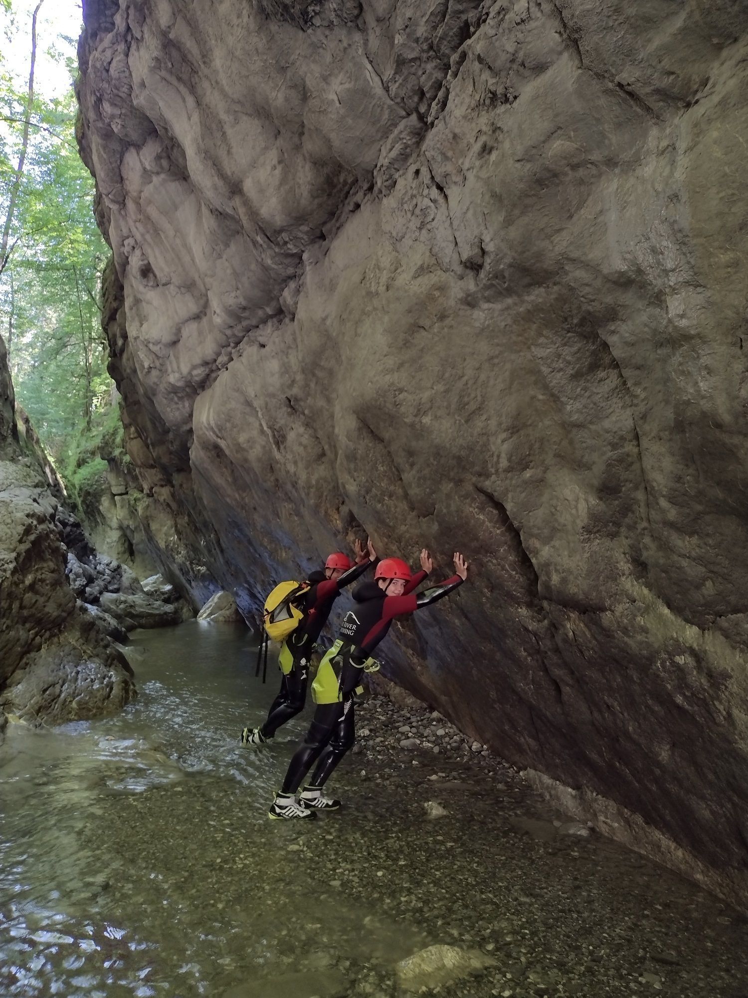 Zwei Canyoning-Gäste halten zusammen einen Felsen in der Tour Merlins World in der Kobelache nahe Dornbirn in Vorarlberg fest
