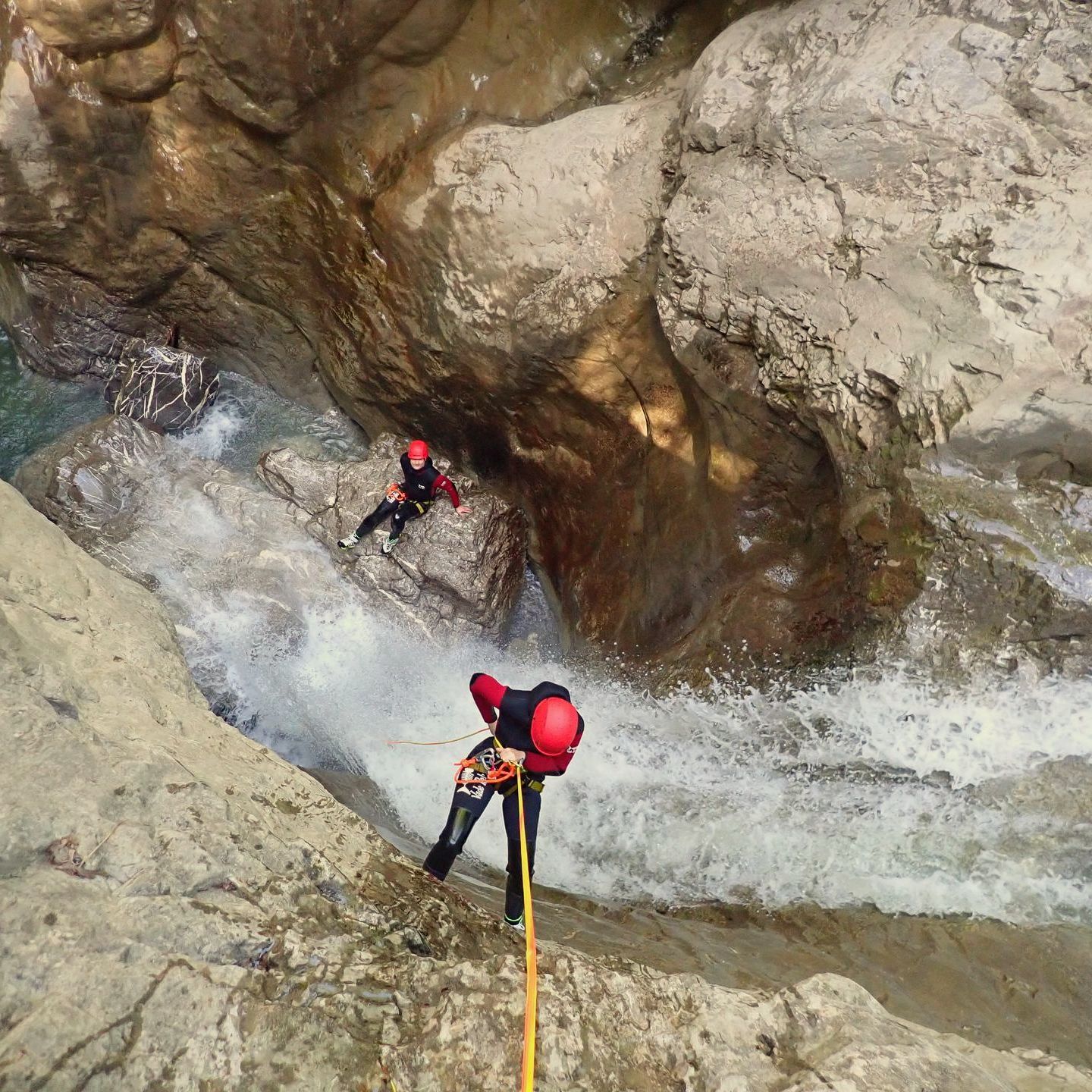 Ein Canyoning-Gast seilt sich 20 Meter über eine Felswand ab
