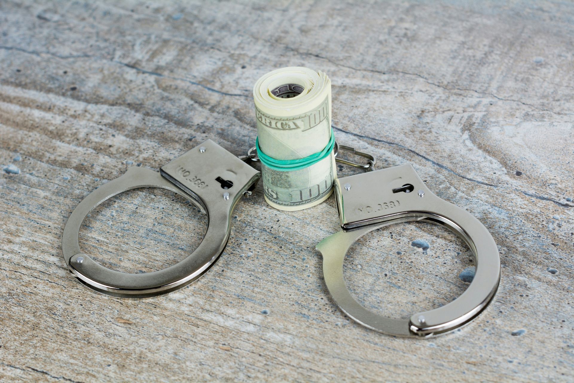 roll of money and handcuffs on table