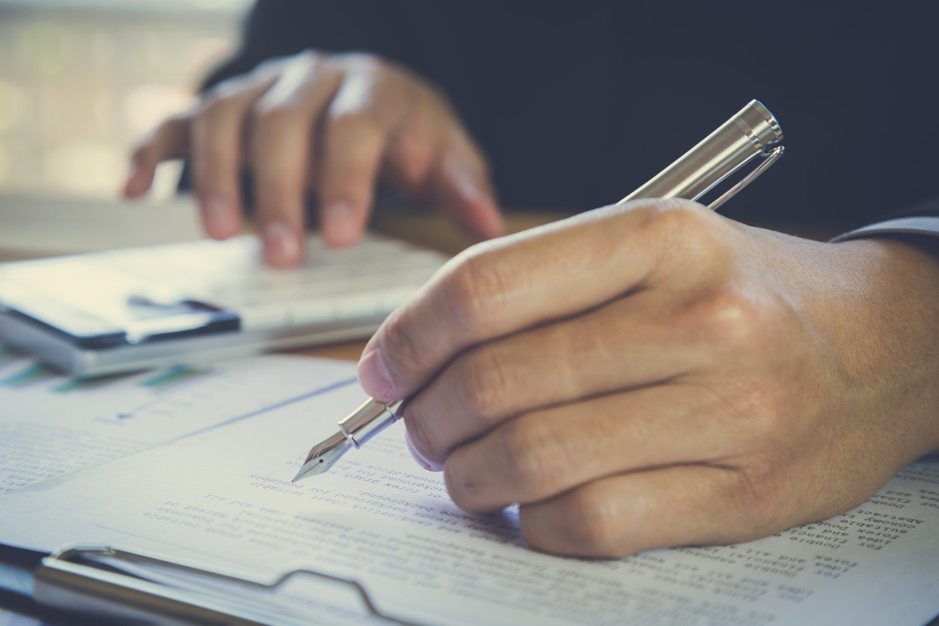 A client of Alliance & Cooper signing paperwork