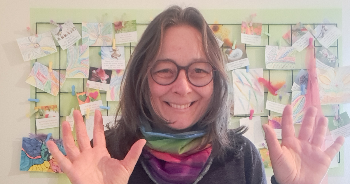 Eine lächelnde Frau, die beide Handflächen in die Kamera zeigt