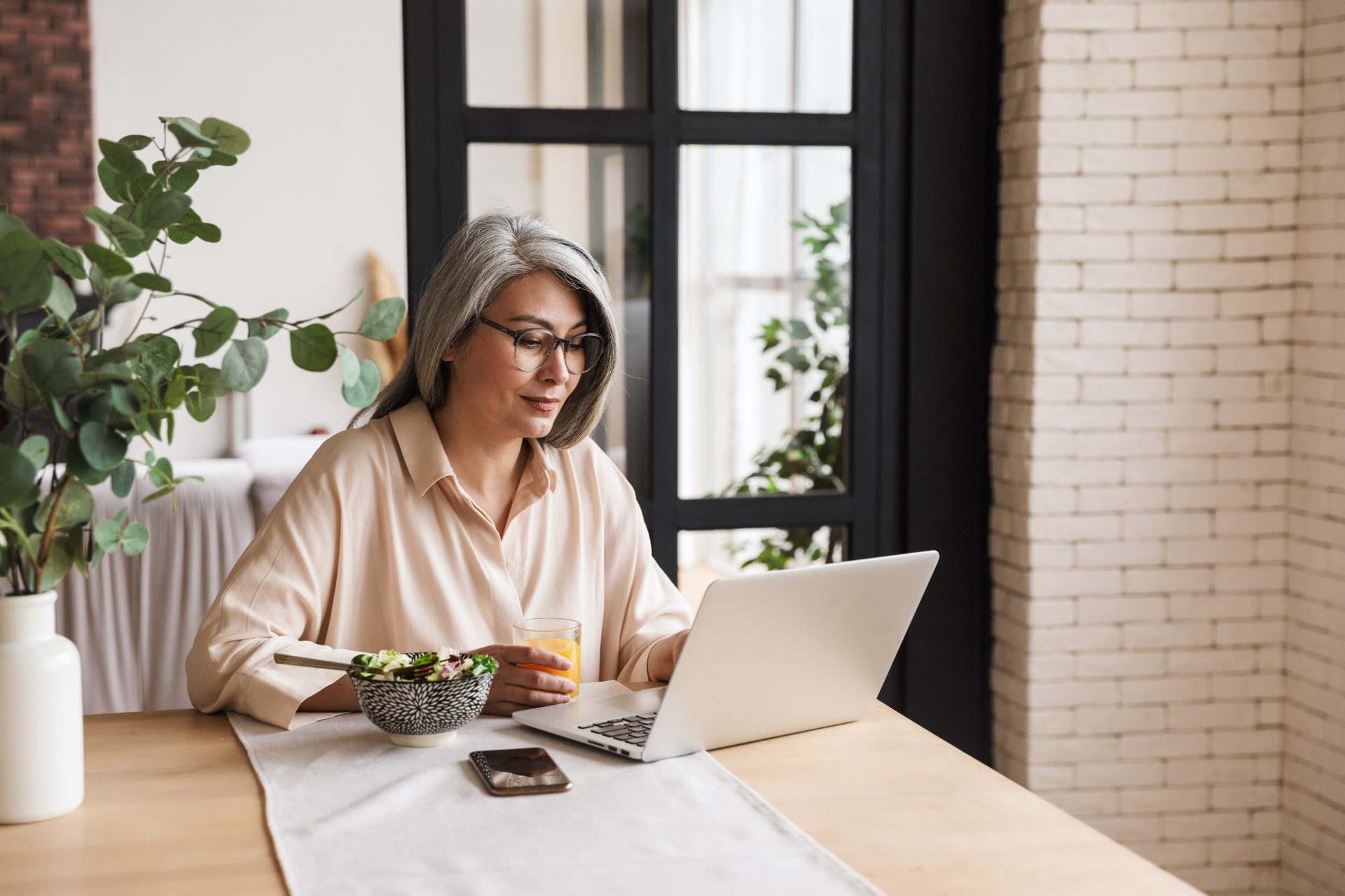 Person sitting at a table looking at their computer.