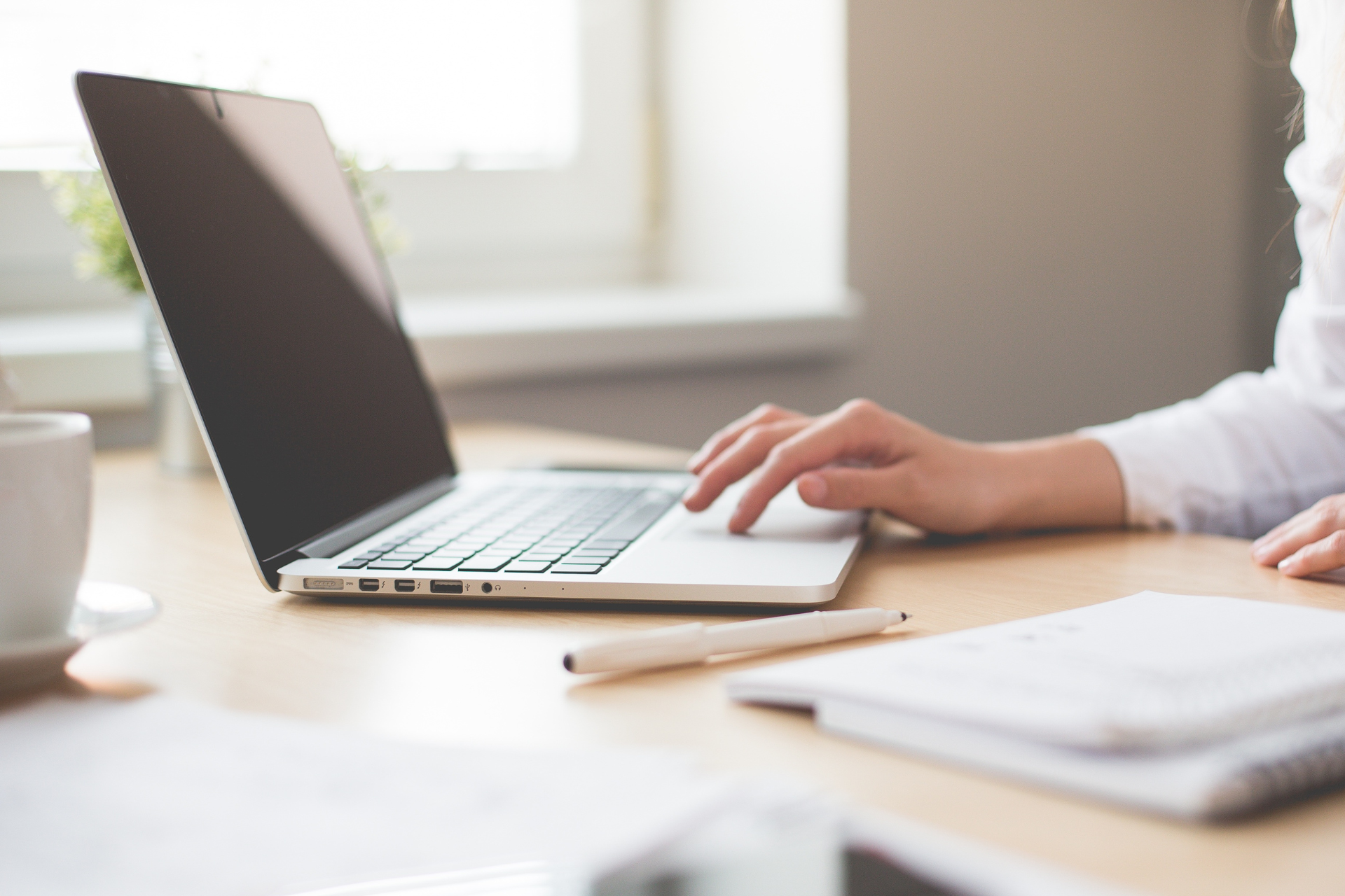 Sitting at desk typing on a laptop