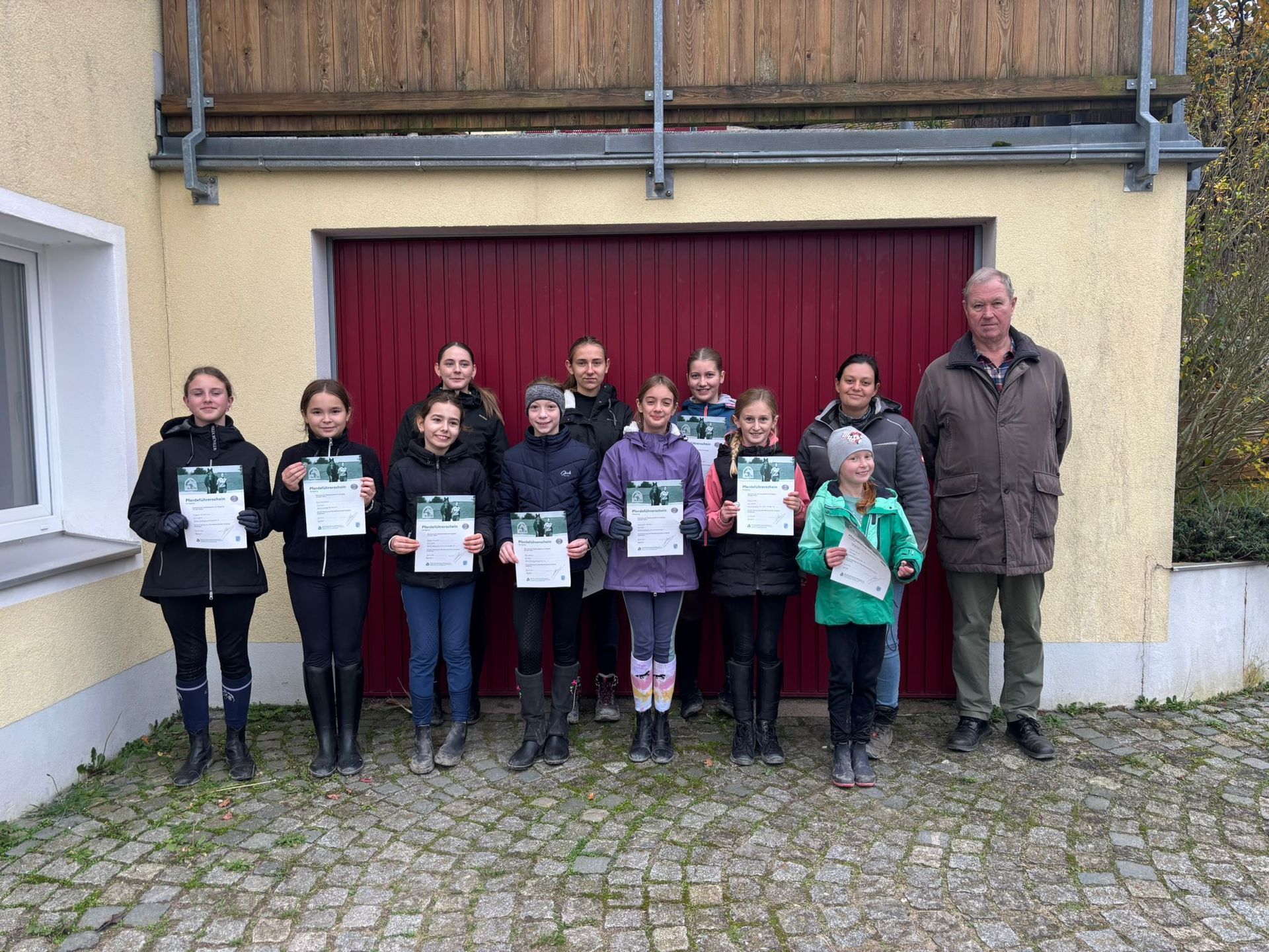 Zehn erfolgreiche Teilnehmer, den Prüfer und die Übungsleiterin des Pferdeführerscheins Umgang am 31.10.2024.