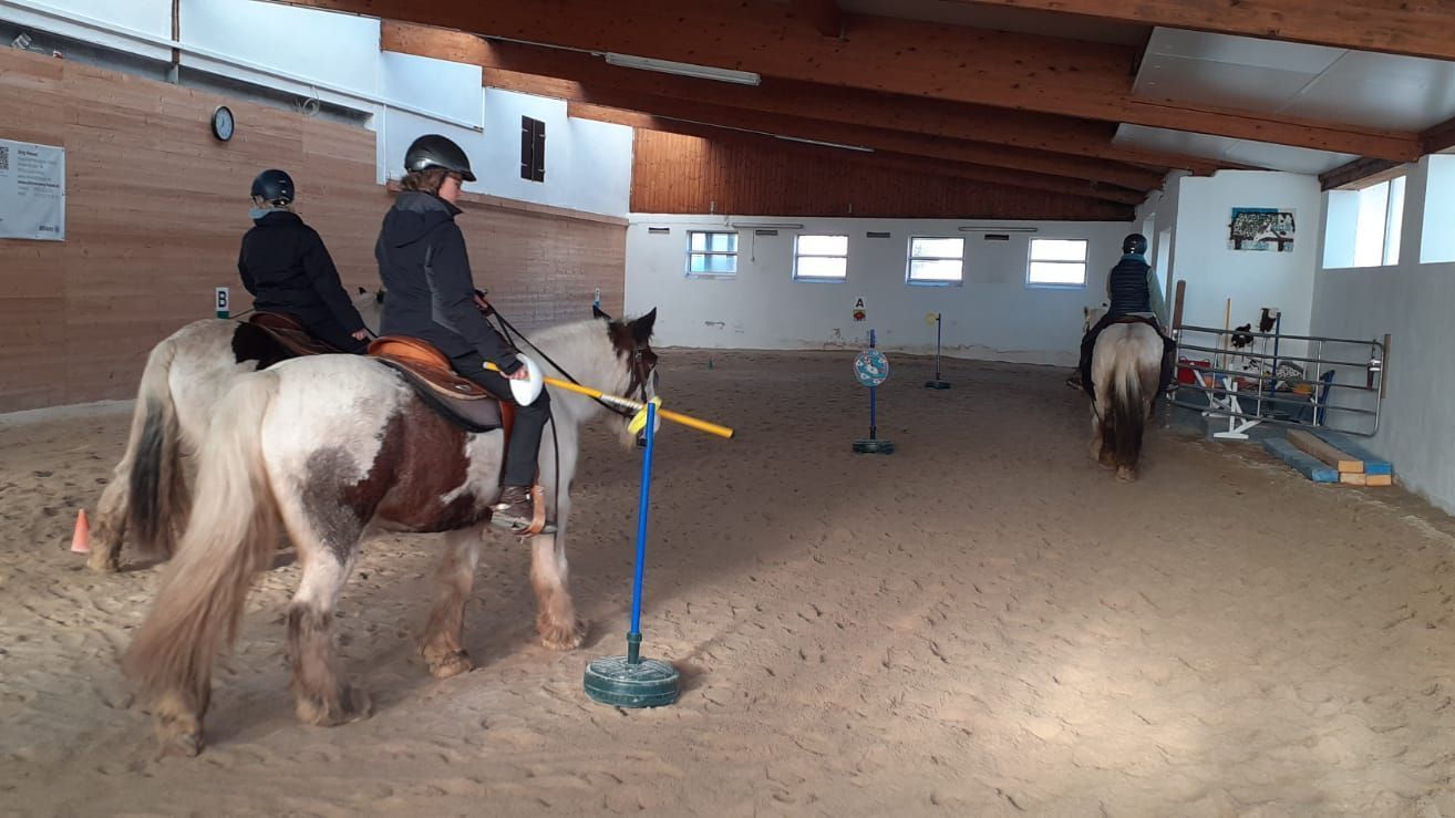 Drei Mädchen nehmen auf Tinkern Reitunterricht in der Reithalle. Drei Mädchen nehmen auf Tinkern Reitunterricht in der Reithalle.