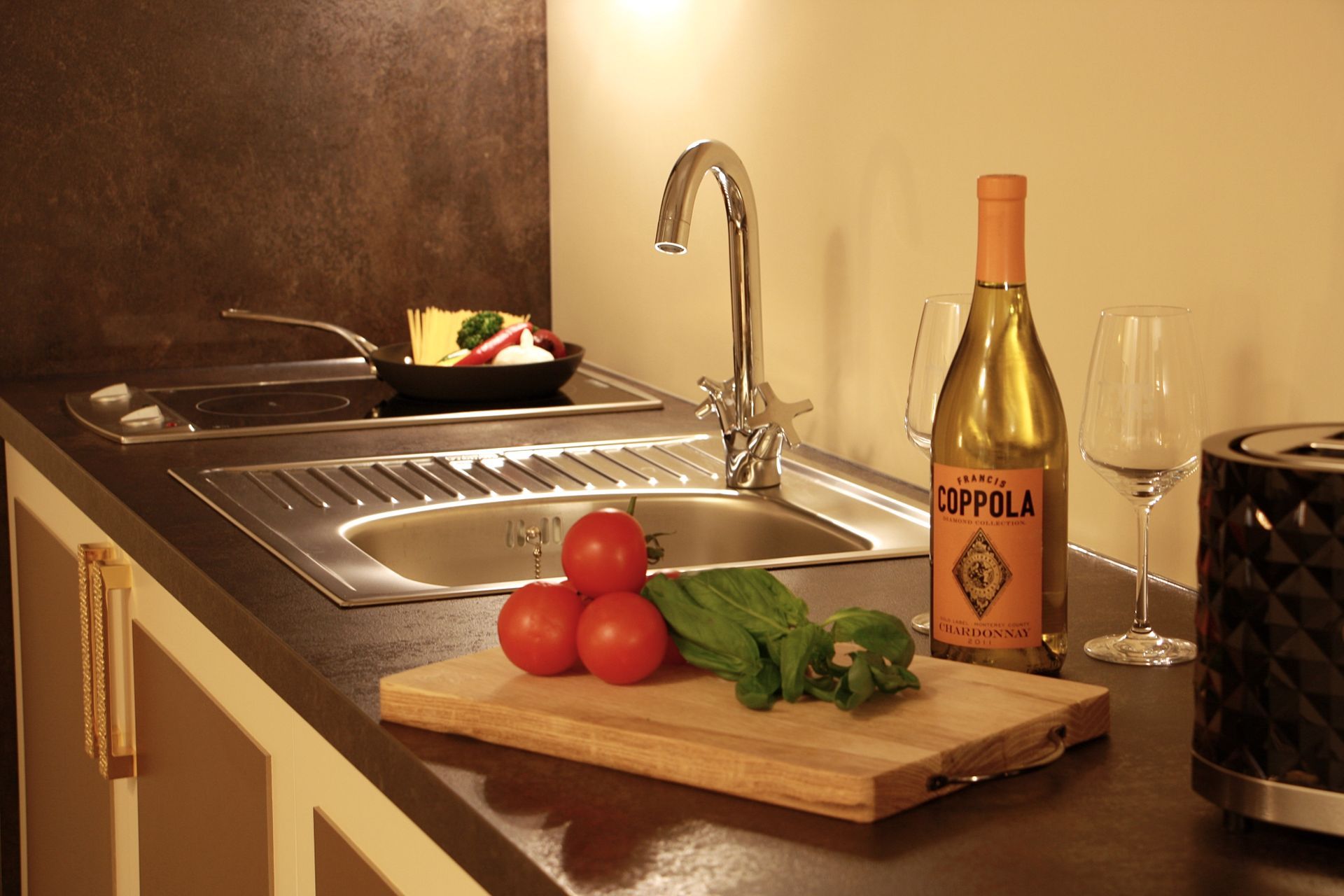 Moderne Küchenzeile mit Edelstahlspüle, Weingläsern und frischem Gemüse – Governor’s Mansion