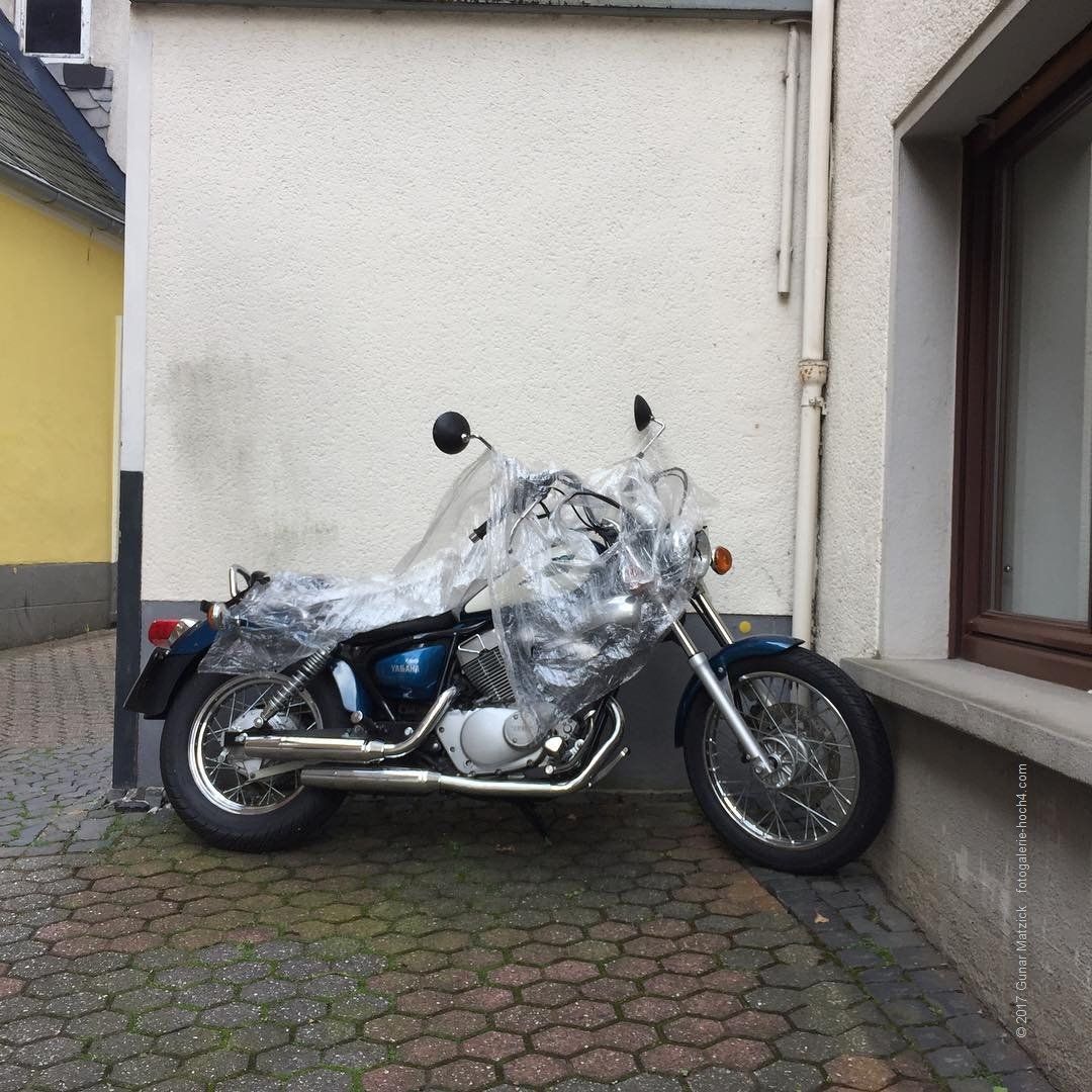 Wer findet den Fehler? Am Tag als der Regen kam. Der Wille war da, das Motorrad zu schützen. Das Hilfsmittel ist doch eher für Malerarbeiten tauglich.