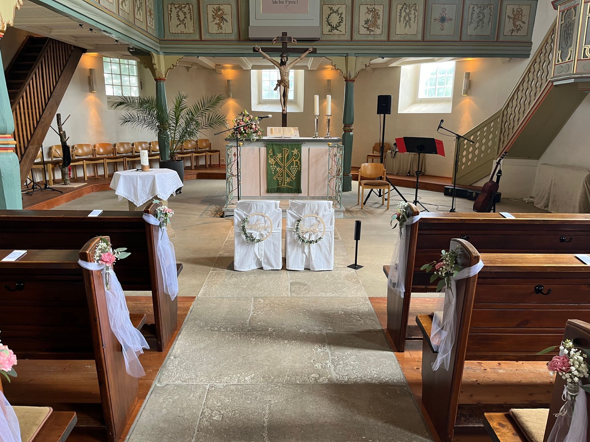 Hochzeitlich dekorierte Kirche mit Altar mit musikalischem Equipment von Daniela Haug