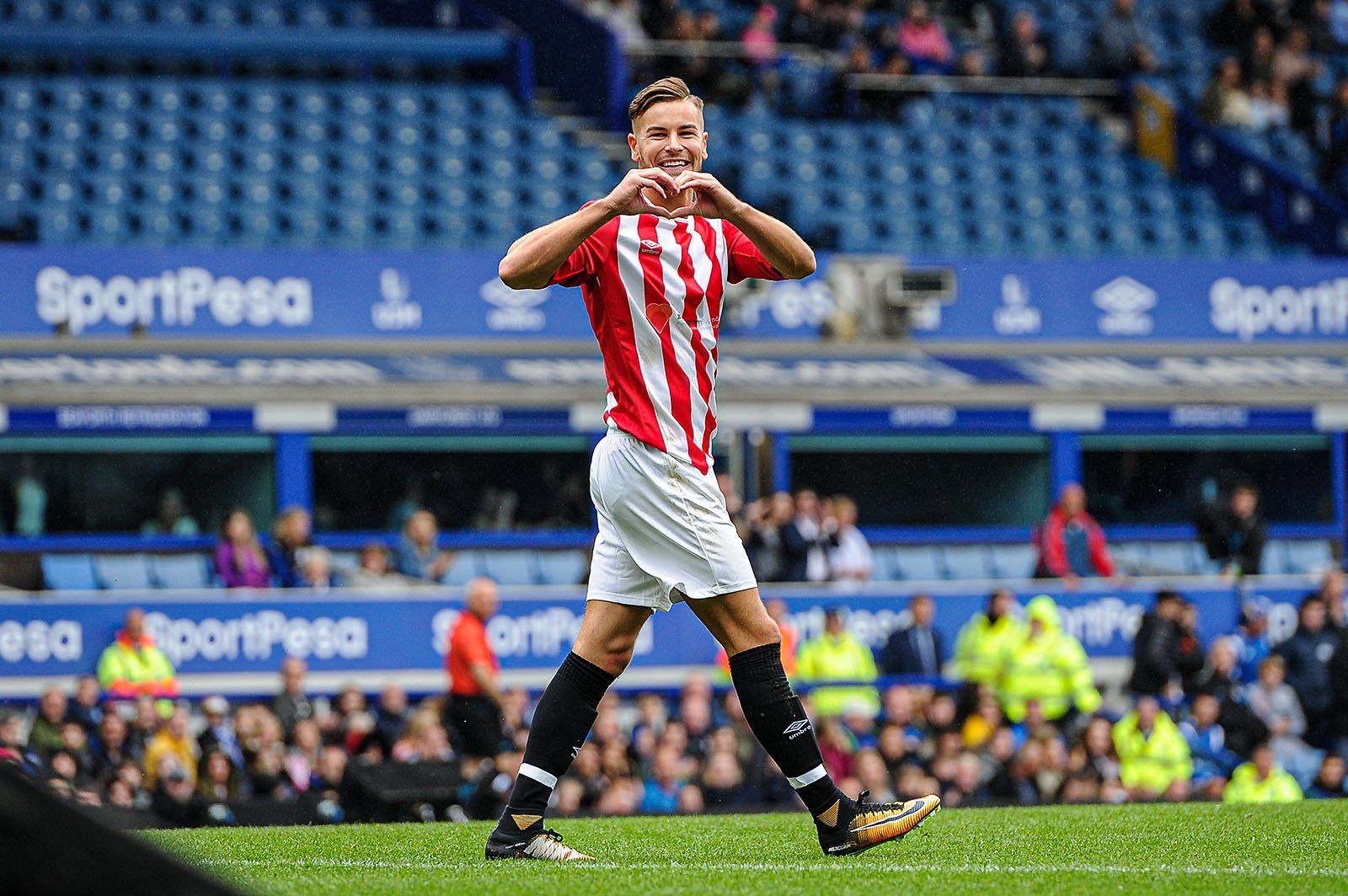 Love Island and Reality TV star Chris Hughes makes a love heart sign with his hands after scoring a goal in a charity match at Everton Football Club.