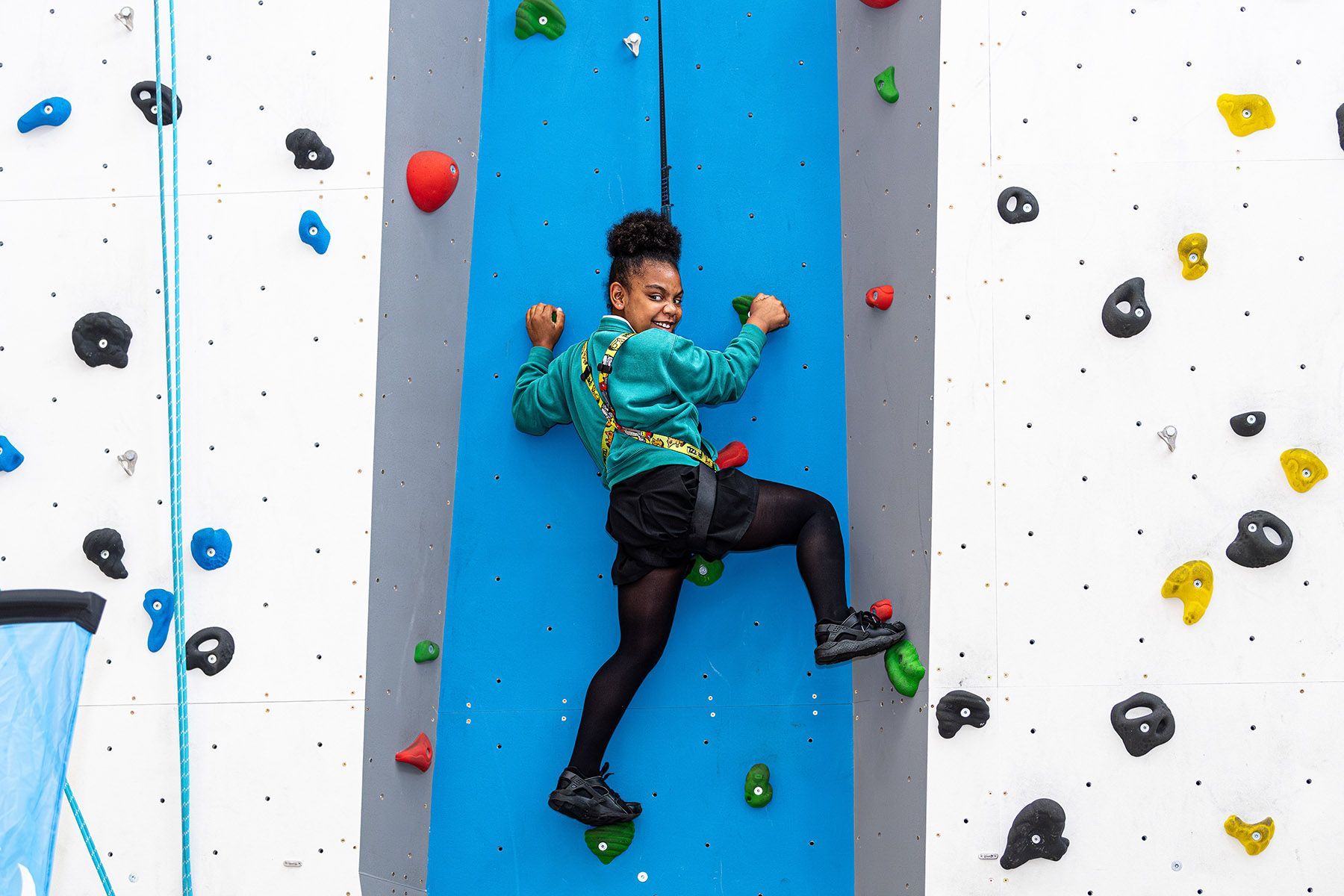 A young girl on a climbing wall.