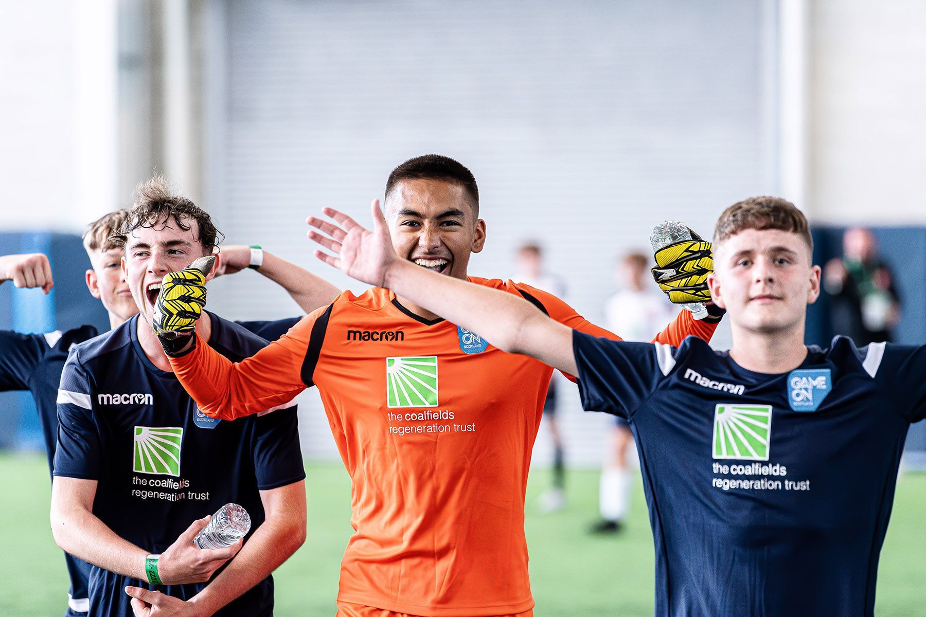 Teenage boys celebrate winning their football game.