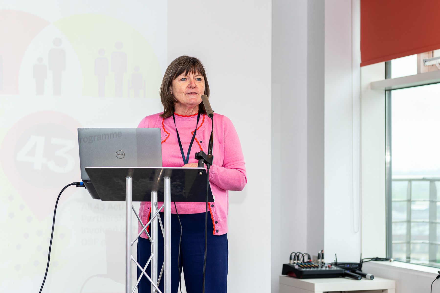 A lady speaks at a conference.