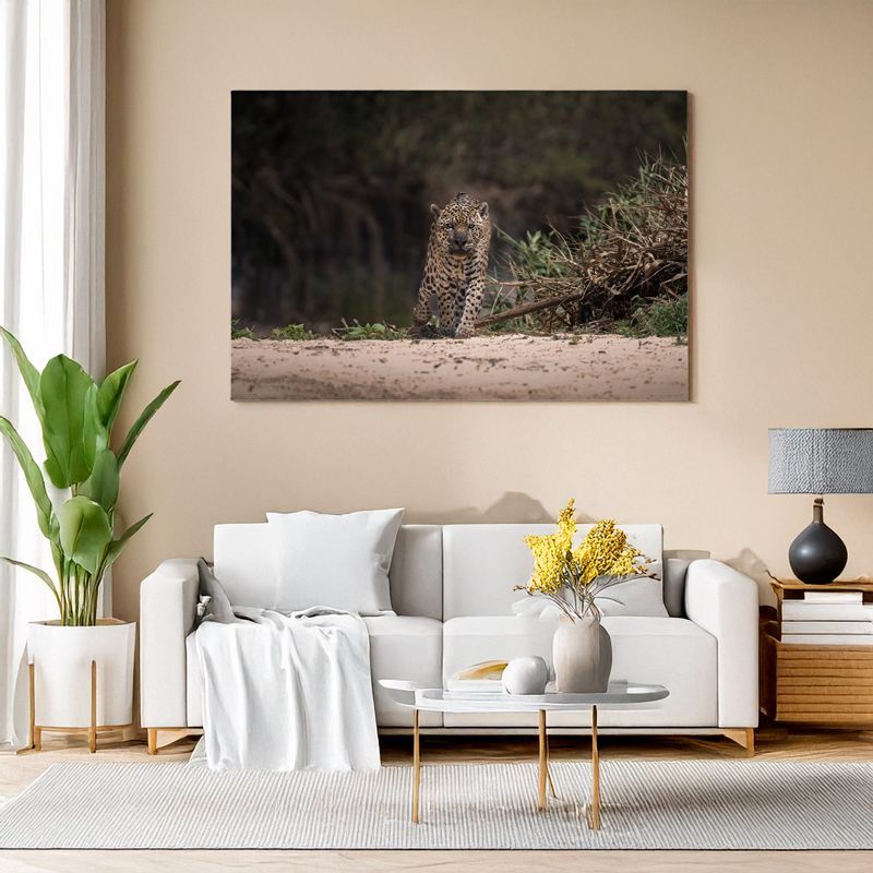 Ein modernes, helles Wohnzimmer mit einem weißen Sofa, einem Couchtisch und Zimmerpflanzen. An der Wand hängt ein großes Foto eines Jaguars, der durch seichtes Wasser läuft und frontal in die Kamera blickt.