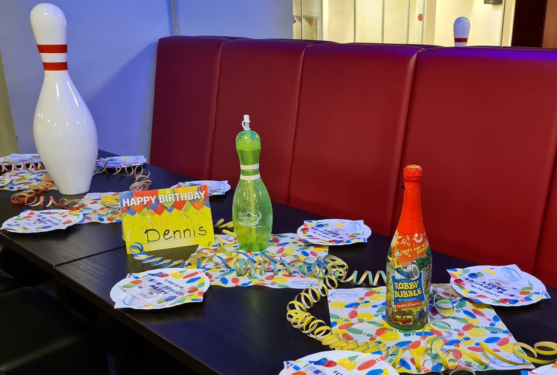 Geburtstagsparty für Jugendliche Bild: Dekorierter Geburtstagstisch mit Luftschlangen, Tellern, Geburtstagsservietten, Pin, Pintrinkflasche und Kindersekt (alkoholfrei)