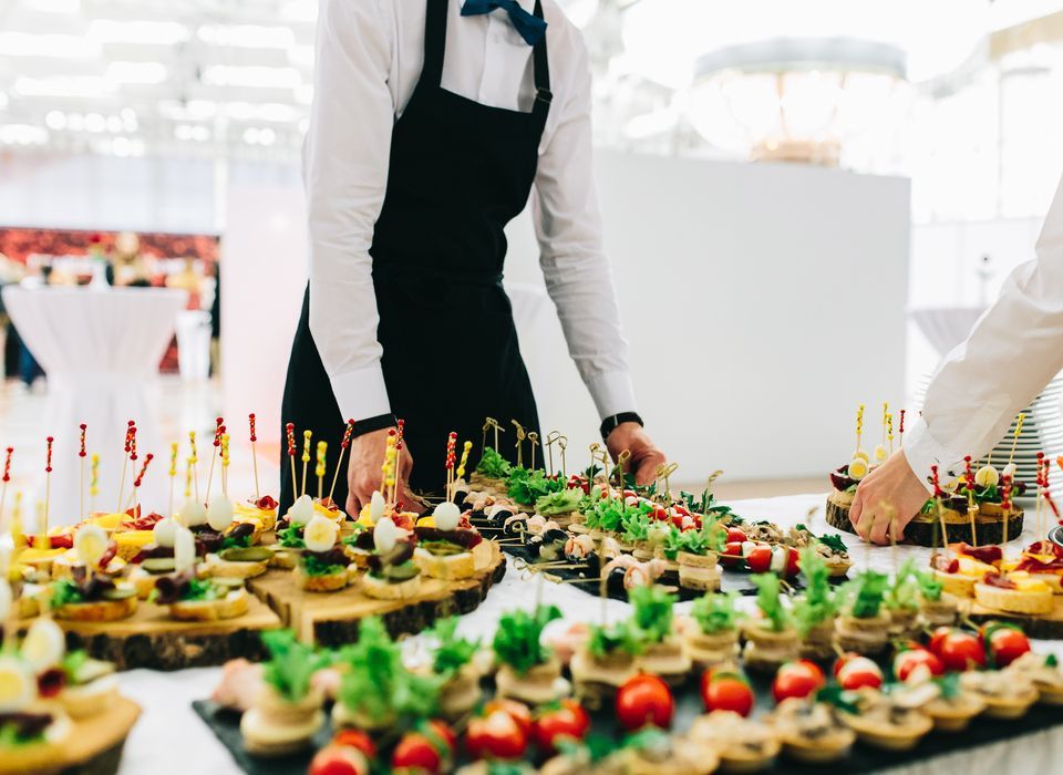 caterers setting up an event table with food