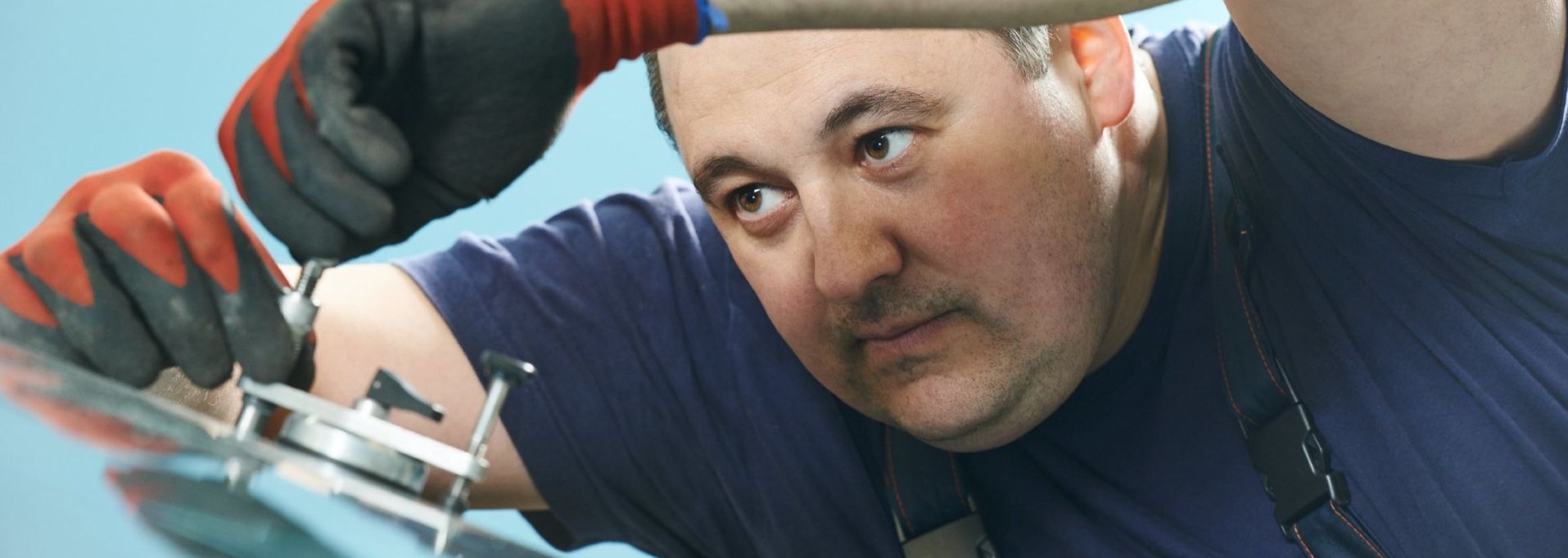 Ein Mann repariert einen GLasschaden