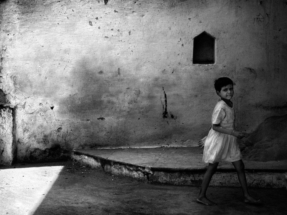 Portrait noir et blanc d'une enfant, jeune fille, passant dans la ville - photo noir et blanc de rue
