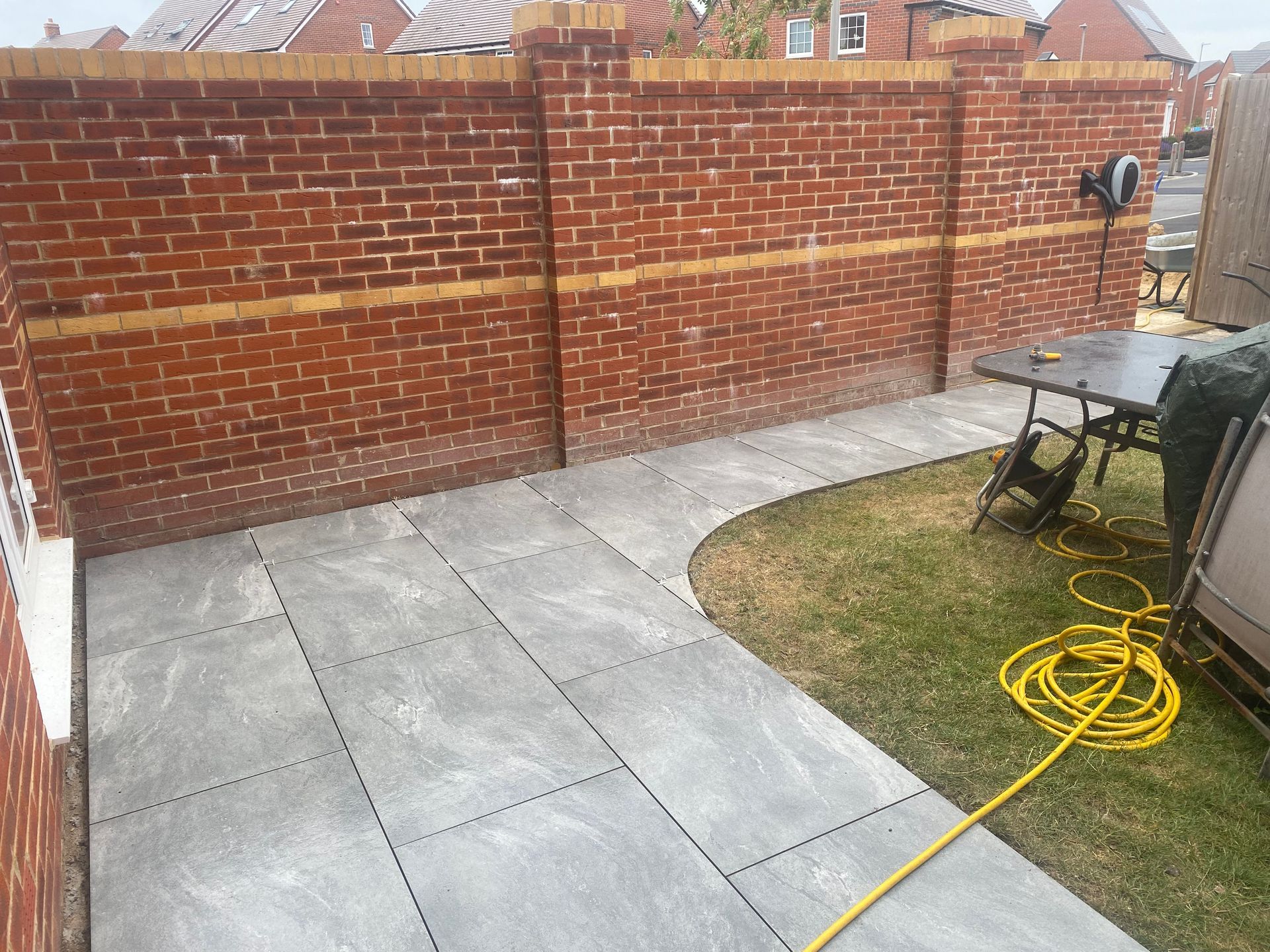 Porcelain paving slab area with brick wall in Poole garden