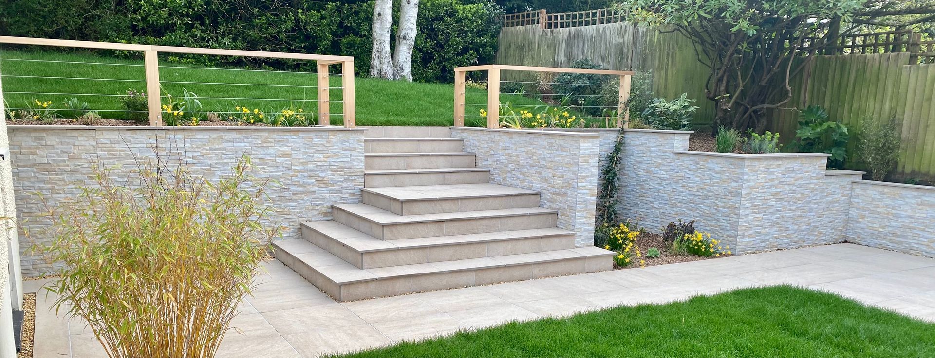 Porcelain paved steps up to raised lawn in Canford Cliffs garden