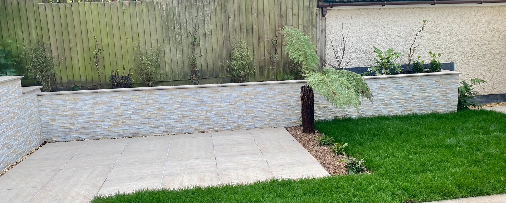 Paved area and porcelain rock cladded wall in Canford Cliffs garden