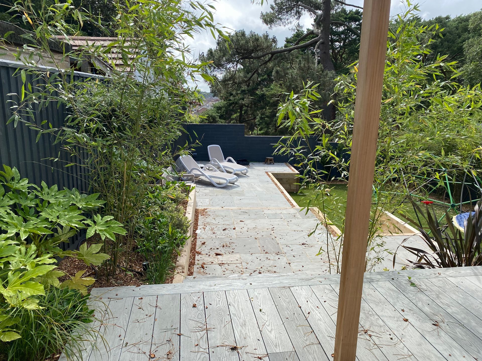 Paved pathway with sun loungers in Parkstone garden