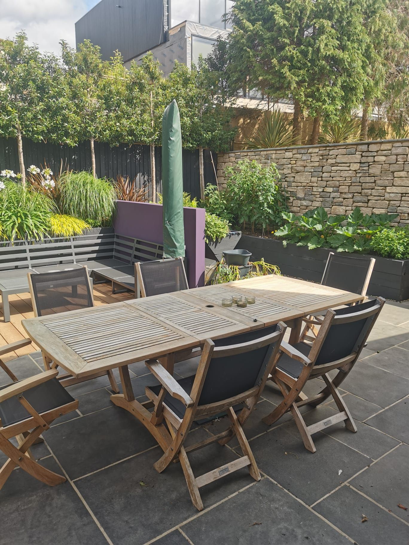 Wooden dining table on patio in Lilliput garden